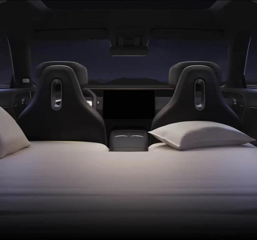 Butacas abatidas formando una cama con almohadas, de noche